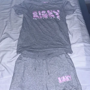 Risky sommar set - Grå shorts i mjukt material med snörning i midjan och tryckt Risky-logga i rosa och vitt på ena benet. Modelen finns ej kvar att köpa