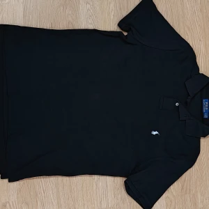 Svart piké från Ralph Lauren - Fin svart RL piké med vit broderad logga på bröstet, väldigt bra skick. Tröjan är i medium och i väldigt mjukt och skönt material. Skulle passa dig runt 180-185 ish. Skriv ifall ni har frågor!