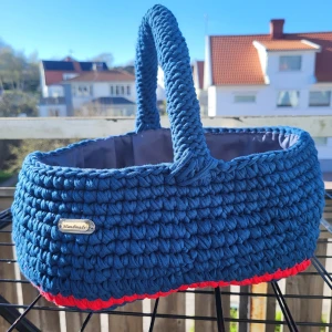 Handgjord blå stickad handväska med röda detaljer - Unik handgjord handväska i blått med röda detaljer och dekorativ nyckelring. Väskan är stickad med tjockt garn och har 1 handtag. Perfekt för dig som vill ha en personlig accessoar med färg. 