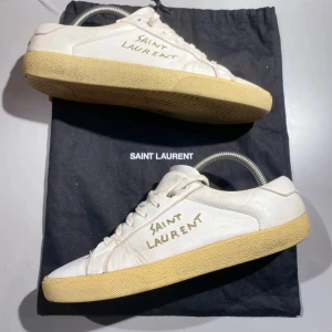 Saint Laurent skor (Ysl Sneakers)  - Snygga trendiga vita sneakers från Saint Laurent. Skorna har vita snören och inga problem i innersulan eller undersidan av skorna. Har såklart tecken på användning, men då skorna kan kosta runt 6000 kr nya så är mitt pris bra. Kan gå ner i pris vid snabb affär 