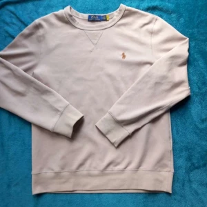Beige sweatshirt från Polo Ralph Lauren - Säljer en stilren beige sweatshirt från Polo Ralph Lauren med klassisk broderad logga på bröstet. Tröjan har rund halsringning och långa ärmar med ribbade muddar. Perfekt för en avslappnad och snygg look.