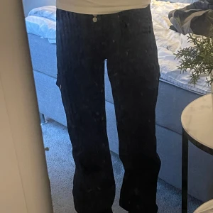 Svarta jeans - Snygga svarta jeans med praktiska fickor och snören vid benen som gör att man lan knyta åt dem. Byxorna har knappar på bakfickorna och en bekväm passform. De är använda ett fårtal gånger. Pris kan alltid diskuteras💕