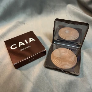 CAIA Bronzer - Bronzer från CAIA i nyansen 'La Digue'. Kommer i en elegant brun förpackning med spegel. Perfekt för att ge ansiktet en solkysst look. Plasten är kvar på den så den är helt oanvänd. Tittade ej vilken färg det var innan jag köpte så därav att jag säljer🤎Hör av dig om frågor!