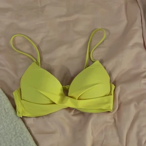 Gul bikiniöverdel Nelly  - Snygg gul bikiniöverdel med smala axelband från Nelly storlek ung 75a (lappen finns ej kvar). Fint skick. 