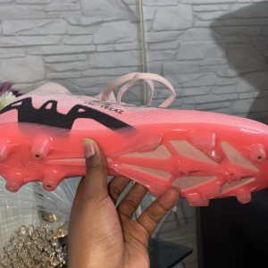 Rosa fotbollsskor med snörning - Snygga rosa fotbollsskor med svart mönster och snörning. Skorna har en strumpliknande passform för extra stöd och komfort på planen. Storlek 42 Inte använda så mycket 3 gånger var för stora för mig. Seriösa köpare MVH Anonym