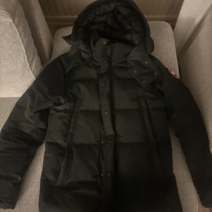Svart dunjacka från Canada Goose - Säljer min fina dunjacka från Canada Goose. Köpt 1 år sedan. Använt denna och förra vintern. Päls finns inte då ja glömde den i Sälen. Har ett litet märke på vänster sida arm längst ner som ni ser på bilden. Såklart äkta.
