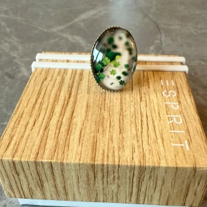 Vintage Ring med Klöverdesign - En vacker vintage ring med en unik klöverdesign. Ringen har en oval form och är tillverkad av metall. Perfekt för den som älskar vintage smycken och vill addera en speciell detalj till sin outfit. Mycket fint skick. Justerbar storlek