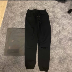 Fear of god  -  svarta mjukisbyxor från fear of god Essentials i storlek XS. Byxorna har en bekväm passform och är oversize. Skick 9/10 nya, och kvitto finns.