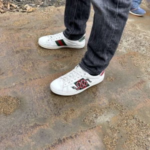GG ace skor - Snygga vita sneakers med ett coolt ormmönster på sidan. Skorna har gröna och röda detaljer på hälen och sidan, vilket ger dem en unik look. Perfekta för dig som vill sticka ut! Självklart äkta tyvärr utan og dock bytt sula under pga skador