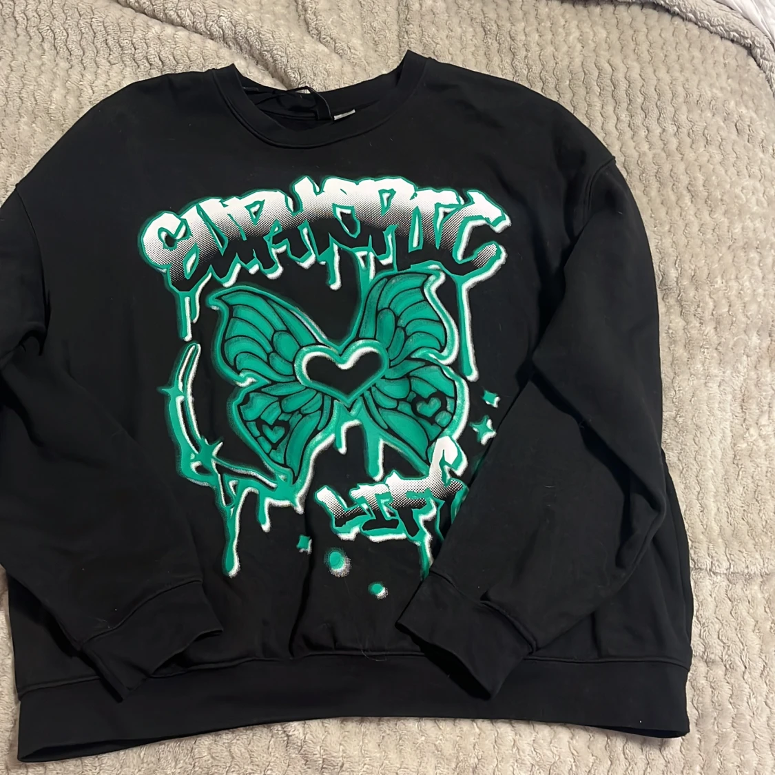 Svart sweatshirt med grön fjärilsdesign