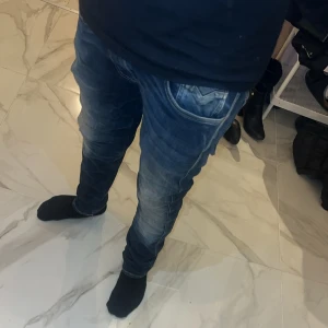 Blå replay anbass jeans - Snygga blå jeansbyxor med en klassisk femficksdesign och en lätt tvättad look. Byxorna har en normal passform och är perfekta för en avslappnad stil. De har en dragkedja och knappstängning framtill.