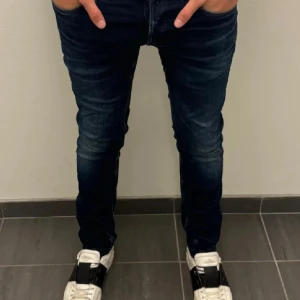 Replay Ambass 32/34 - Snygga mörkblå jeans från Replay med en slim passform. De har en klassisk femficksdesign och en knappgylf. Perfekta för en stilren look. St 32/34 Nypris 1699, helt nya utan slitningar, bara o höra av sig😁