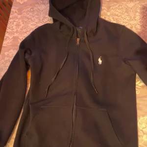 Svart hoodie från Ralph Lauren - Säljer denna snygga polo zip. Riktigt fräsch och använd fåtal gånger. Storlek M, passar S. 