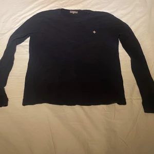  tröja från Morris - Säljer en stilren tröja från Morris med en liten broderad detalj på bröstet. Tröjan har långa ärmar och är perfekt för en klassisk look. Passar bra till både jeans och chinos.