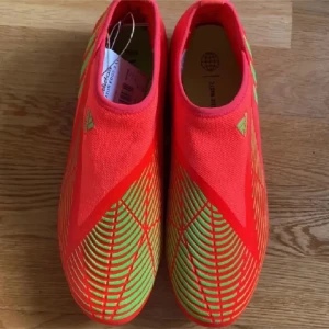 Röda fotbollsskor från Adidas - Snygga röda fotbollsskor från Adidas med gröna detaljer och mönster. Skorna har en strömlinjeformad design och är perfekta för fotbollsplanen. De har en tight passform och är tillverkade i syntetmaterial. I bra skick har bara använts vid 2 tillfällen hör av er för mer info 👍🏼