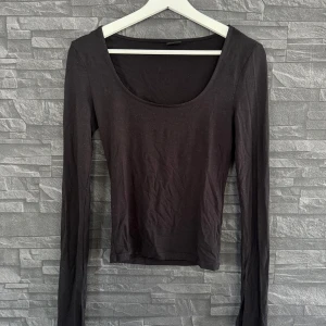 Gina tricot topp - Långärmad svart tröja från Gina tricot med slits och urringad, soft touch. Gått upp lite i sömmen men inget som syns eller påverkas (bild 2)