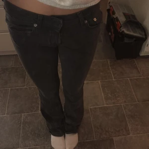 Svarta jeansbyxor - Snygga svarta jeansbyxor med låg midja och en tight passform. Byxorna är lite slitna längst ner på det högra benet.