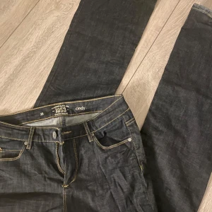 Svarta jeansbyxor från 1953 Cindy - Snygga mörka jeansbyxor från 1953 Cindy med klassisk femficksdesign och kontrasterande sömmar. Byxorna har en flare passform och har storlek 38