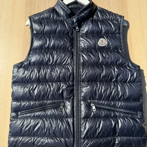 Moncler gui väst blå - Hej, säljer nu min Moncler gui väst i storlek 2 i blå färg. Den är i bra skick utan hål och andra skador.   Hör gärna av dig om du har några frågor!   Mvh Oliver 