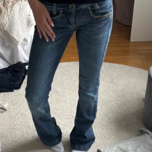 Bootcut jeans från Miss Sixty - Snygga blå bootcut jeans från Miss Sixty med klassiska orange sömmar och läderpatch bak. Jeansen har låg midja och är tillverkade i mjukt denim med lätt slitning framtill. Perfekta för dig som gillar en retro vibe och vill ha ett par jeans med riktigt bra passform. Supersnygga och aldrig använda nästan!!❤️midjemått 35cm och innerbenslängd 83cm!