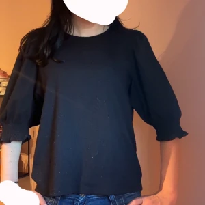 Svart blus med puffärm - En svart blus med rund halsringning och puffiga trekvartsärmar som avslutas med smock. Enkel och stilren modell som passar till jeans eller kjol. Tidlös och lätt att matcha med olika accessoarer. Storlek M men passar mej som brukar ha XXS/XS/S ! Använd några få gånger men så gott som ny! Pris kan diskuteras 💓🥰