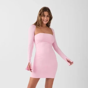 Ljusrosa långärmad klänning Gina Tricot - Supersöt ljusrosa kortklänning från Gina Tricot med långärmade ärmar med slits och snygg drapering fram. Klänningen har en tight passform och är gjord i ett mjukt, stretchigt material. Perfekt för dig som vill sticka ut med en ljusrosa look. Klänningen är bara använd en gång.