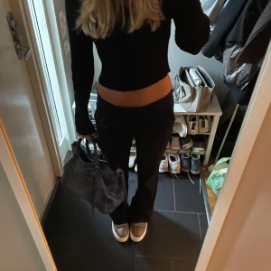 Svarta bootcut byxor med låg midja - Säljer ett par svarta kostymbyxor med bootcut-modell och låg midja från Filippa K. Storlek XS, passar S också. 