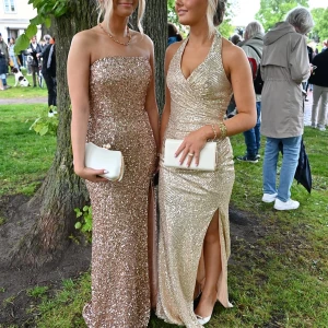 Off shoulder klänning  - Säljer en superfin långklänning i guldig ton med massor av paljetter som glittrar. Klänningen är axelbandslös, figurnära och har en snygg dragkedja i ryggen. Perfekt för bal och fest. Klänningen kommer från märket dressroome och är andats använd en gång! Nypris 5000kr men säljer för endast 2999! Pris kan dock diskuteras 