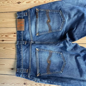 Blå Grim Tim från Nudie Jeans - Snygga blå jeans från Nudie Jeans i modellen Grim Tim. Extremt snygg wash, vilket ger en laidback känsla. 