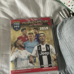 Adrenalyn XL Official Collector's Album (FIFA 365, Premier League, UEFA Euro, 2019-2022) - Samling av Panini Adrenalyn XL-album med officiella samlarkort från FIFA 365, Premier League och UEFA Euro 2020. Perfekt för dig som älskar fotboll, samlar på kort och vill ha koll på världens bästa lag och spelare det är ungefär 500 kort i pärmen tyvärr så kan jag inte visa alla kort eftersom man bara kan ta fem bilder.