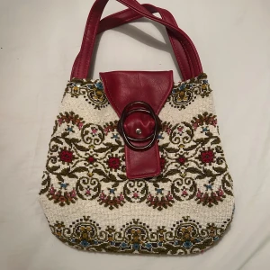 Broderad handväska med röda detaljer - Säljer en handväska med broderat blommönster. 