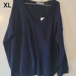 Mörkblå stickad tröja XL - En oversized mörkblå stickad tröja från 1517 i storlek XL. Tröjan har en djup v-ringning och långa ärmar, perfekt för lager-på-lager. Den grova stickningen ger en chill och avslappnad vibe.