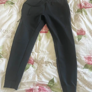 Svarta nike tech fleece - Snygga svarta Nike tech byxor i strl S. Detta är den gamla modellen som är lite mer slim fit än de nya modellerna. Rekommenderar dessa om du har xs i de nya modellerna. Ganska sällsynt att få tag på. Byxorna är i bra skick.