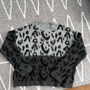 Stickad tröja leopard - Stickad tröja i svart och grått leopard mönster. Använd men i fint skick.  Storlek S. Köparen står för frakten🩷