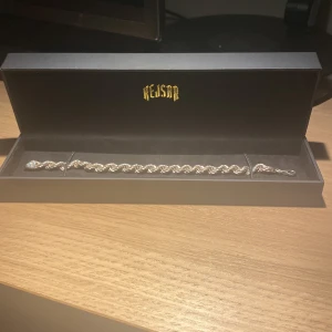 Silverpläterat armband från Kejsar - Snyggt armband i pläterat 925 silver från Kejsar. Armbandet har en tvinnad kedjedesign som ger en cool och stilren look. Perfekt accessoar för att lyfta din outfit. Levereras i original ask med Kejsar-logga i guld.