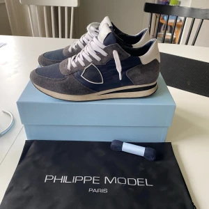 Philippe Model sneakers blå/grå - Ett par Philippe model skor som är knappt använda, säljer för att jag inte använder dom längre. Allt på bilden ingår. Skon är relativt stor i storleken, jag har 43 i alla mina andra skor och dem passar mig bra. Det är bara höra av dig om du har någon fråga ! 