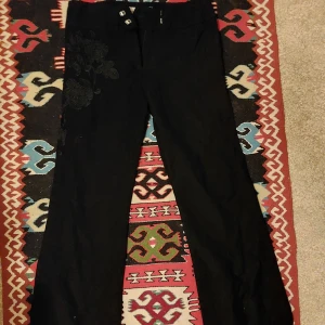 Svarta byxor med broderade detaljer - Vackra kostymbyxor från karen millen med söt brodyr på, står s men tycker de känns närmre xs