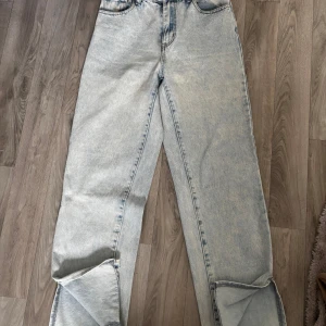 Ljusblå raka jeans med vintagekänsla - Säljer ett par ljusblå jeans med rak passform och klassisk femficksdesign. Jeansen har en tvättad, nästan blekt look som ger en retrovibe. Tillverkade i jeansmaterial och passar perfekt till en avslappnad stil.