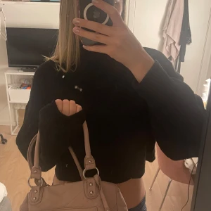 Svart croppad polotröja från H&M Divided - Svart stickad polotröja från H&M Divided i croppad modell. Tröjan har breda, långa ärmar och hög krage. Perfekt för lager-på-lager och chill stil. Mjuk och skön, passar till jeans eller kjol.💙🫶