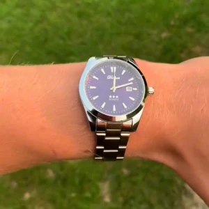 Blå klocka från doventi - Stilren klocka från Denvosi med blå urtavla och silverfärgat armband i metall. Klassisk rund form, tydliga index och datumvisning. Perfekt accessoar för dig som gillar en clean och modern look. Quartz-urverk och robust länkarmband i silver.