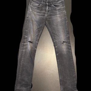 Grå skinny jeans från dondup - Snygga grå skinny jeans från dondup med slitningar på båda knäna och coola detaljer på bakfickorna. Passar även perfekt som slim fit. Jeansen har en klassisk femficksdesign. Perfekta för dig som gillar en edgy och trendig stil.