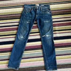 Blå Replay Anbass med slitningar  - Säljer nu dessa extremt eftertraktade replay anbass jeans. Byxorna är i mycket bra skick och helt defektfri. Kontakta vid minsta fråga! W30 L30