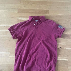 Röd pikétröja Ralph Lauren - Säljer nu en röd pikétröja från Ralph Lauren Denim & Supply med klassisk krage och två knappar. Finns få tecken på användning men inget man lägger märke till!