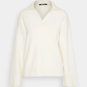 Vit stickad polotröja/ Eastside stickad tröja - Säljer en vit stickad polotröja från Bikbok med v-ringad hals och krage. Tröjan har långärmade, loose passform och breda ribbade muddar vid ärmslut och nederkant. Perfekt för dig som gillar stilrena och mjuka plagg. Väldigt skön tröja, funkar bra för alla väder. Använt ett par gånger!