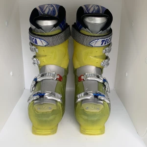 Gula pjäxor från Tecnica - Säljer ett par gula och silverfärgade pjäxor från Tecnica med fyra spännen i metall och justerbara remmar upptill. Pjäxorna har en genomskinlig gul plast och blå detaljer på insidan av skaftet. Perfekta för skidåkning.
