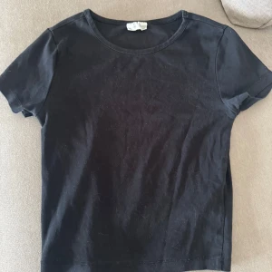  basic t-shirt - Svart basic t shirt från Gina tricot, lappen är urtvättad men vad jag kan se är den i storlek S. Förutom lappen är den i bra skick!