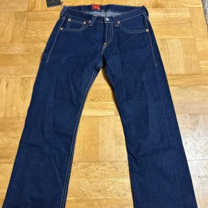Levi's 901 blå jeans - Klassiska blå jeans från Levi's modell 901 med raka ben och kontrastsömmar. Byxorna har fem fickor och tydlig Levi's-lapp bak i midjan. Storlek W 33 L 34 KOM MED PRISFÖRSLAG 