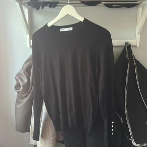 Svart långärmad tröja från Zara med knappar - Säljer en svart långärmad tröja från Zara. Tröjan har rund halsringning och dekorativa silvriga knappar vid ärmsluten. Enkel och stilren modell som passar till mycket. Väldigt fint skick säljer för att jag har flera som är liknande 💕