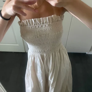 Beige bandeau klänning - Säljer en beige snygg bandeau klänning. I mycket bra skick, perfekt till sommaren