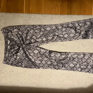 Ormskinns byxor - Ett par byxor med ormiskinns mönster från weekday🥰de är typ straight/flare och endast använda 2 gånger. Storlek 34